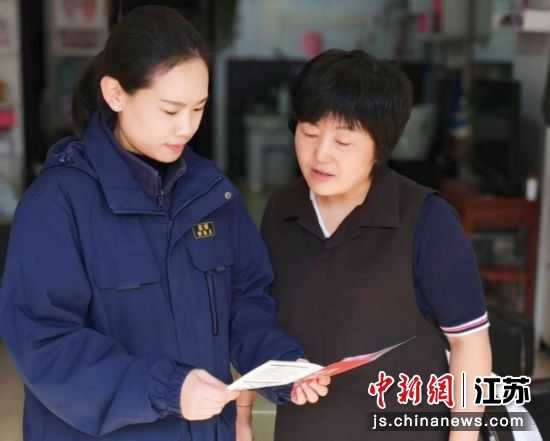 网格员向居民发放宣传折页。 铜建社区 供图 网格员向居民发放宣传折页。 铜建社区 供图