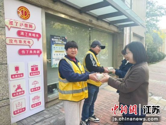 志愿者向户外劳动者递送饺子。凯旋门社区 供图 志愿者向户外劳动者递送饺子。凯旋门社区 供图