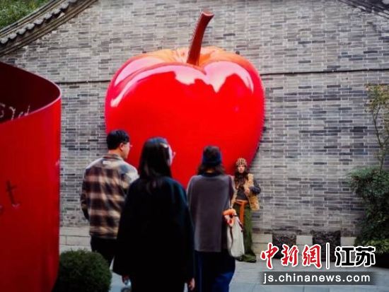 游客在文庙街区巨型苹果景观前驻足拍照。文庙街区 供图 游客在文庙街区巨型苹果景观前驻足拍照。文庙街区 供图