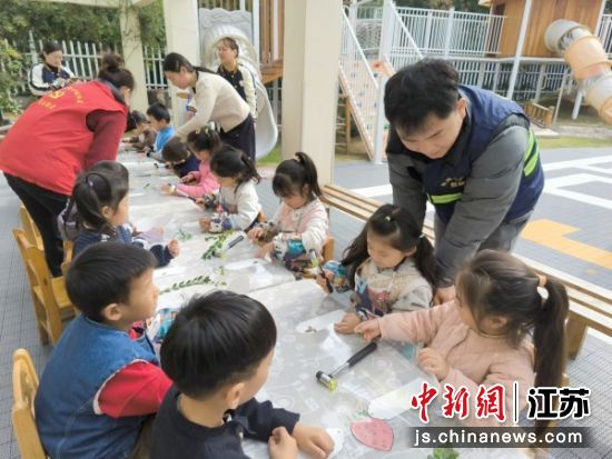 小朋友们在志愿者、网格员的帮助下制作叶脉书签。王璐 摄 小朋友们在志愿者、网格员的帮助下制作叶脉书签。王璐 摄