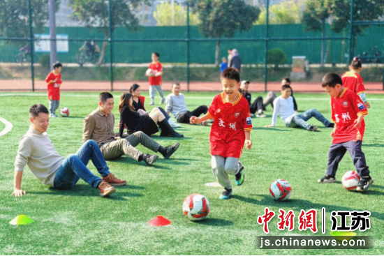 家长和孩子们参与足球训练。王思哲 摄 家长和孩子们参与足球训练。王思哲 摄