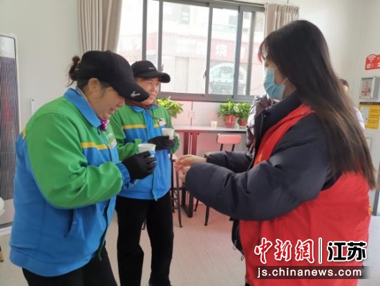 志愿者为户外工作者送上姜茶。九里街道 供图 志愿者为户外工作者送上姜茶。九里街道 供图