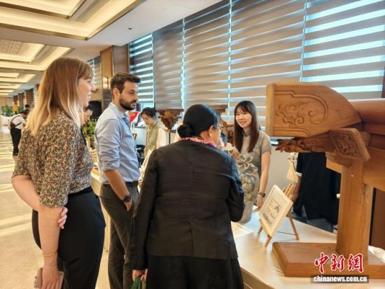 戈玉兰(右一)向海外参观者介绍江南传统古建的构件。 受访者供图 戈玉兰(右一)向海外参观者介绍江南传统古建的构件。 受访者供图