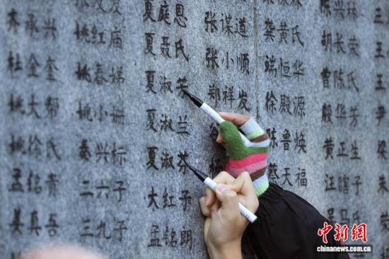 11月30日,夏家亲属在侵华日军南京大屠杀遇难同胞纪念馆南京大屠杀遇难者名单墙(又称“哭墙”)前,为家族遇难的家属姓名描新。中新网记者 泱波 摄 11月30日,夏家亲属在侵华日军南京大屠杀遇难同胞纪念馆南京大屠杀遇难者名单墙(又称“哭墙”)前,为家族遇难的家属姓名描新。中新网记者 泱波 摄