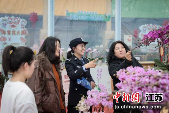 民警向前来购花的群众讲解反诈知识。陆华 摄 民警向前来购花的群众讲解反诈知识。陆华 摄