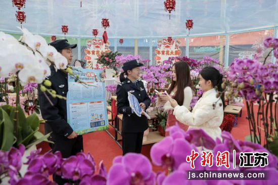 民警向前来购花的群众讲解反诈知识。陆华 摄 民警向前来购花的群众讲解反诈知识。陆华 摄