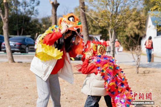 2月18日,苏州市吴中区旺山,两岸婚姻家庭的母子一起戴着舞狮道具嬉戏。 中新社记者 钟升 摄 2月18日,苏州市吴中区旺山,两岸婚姻家庭的母子一起戴着舞狮道具嬉戏。 中新社记者 钟升 摄