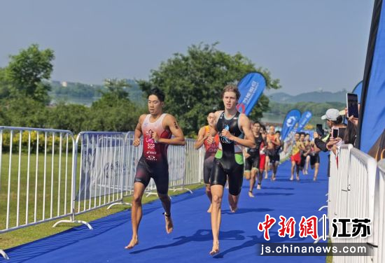 运动员们游泳结束以后奔跑在跑步赛道。 朱梓 摄 运动员们游泳结束以后奔跑在跑步赛道。 朱梓 摄