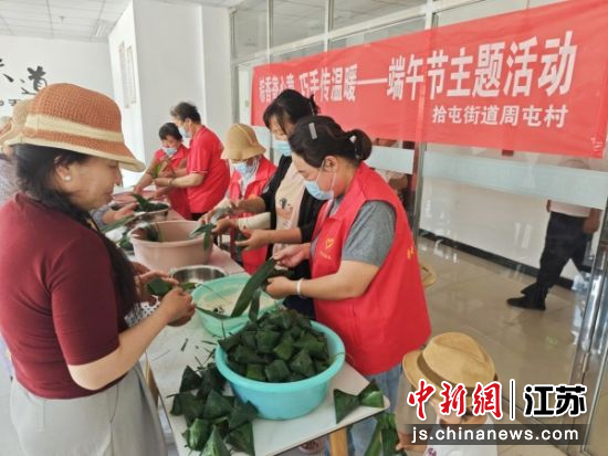 志愿者们包粽子。拾屯街道周屯村 供图 志愿者们包粽子。拾屯街道周屯村 供图