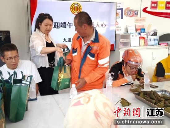工作人员发放节日礼品。九里街道 供图 工作人员发放节日礼品。九里街道 供图