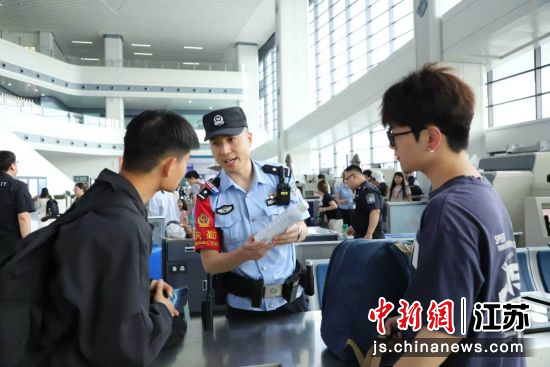 民警在安检处向旅客讲解铁路乘车禁止携带的物品种类。刘涛 摄 民警在安检处向旅客讲解铁路乘车禁止携带的物品种类。刘涛 摄