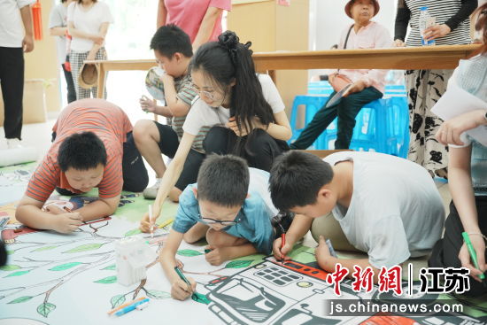 大学生志愿者与居民共绘消防主题长卷。王珂菡 摄 大学生志愿者与居民共绘消防主题长卷。王珂菡 摄