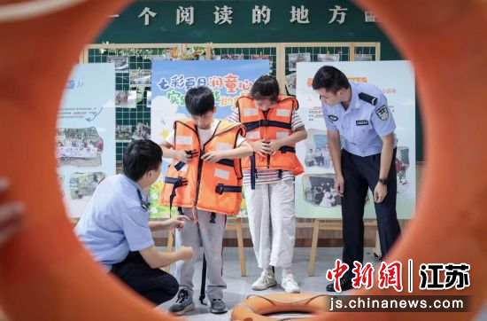 民警指导孩子穿救生衣。 民警指导孩子穿救生衣。