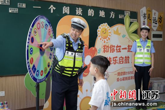 民辅警利用交通安全大转盘为孩子们讲解交通安全知识。 民辅警利用交通安全大转盘为孩子们讲解交通安全知识。