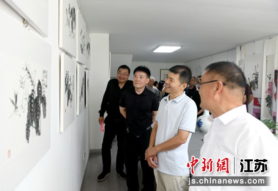 张顺平(右二)向来宾介绍作品。王松竹 摄 张顺平(右二)向来宾介绍作品。王松竹 摄