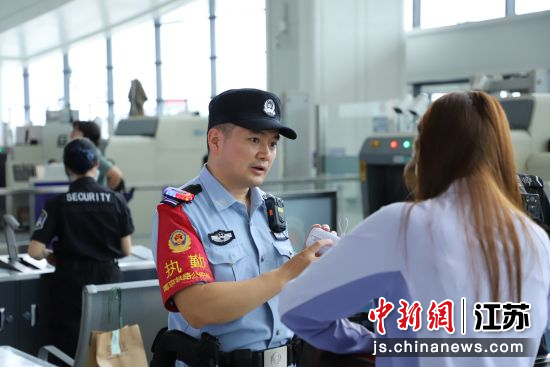 民警在安检处向旅客宣传铁路禁止携带物品种类。刘涛 摄 民警在安检处向旅客宣传铁路禁止携带物品种类。刘涛 摄