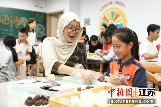 留学生与小学生并肩协作制作月饼,欢声笑语间,沉浸式体验中秋传统习俗,感受中华文化魅力。 留学生与小学生并肩协作制作月饼,欢声笑语间,沉浸式体验中秋传统习俗,感受中华文化魅力。