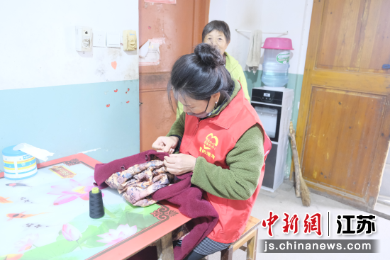 志愿者帮群众缝补衣服。朱晓东 摄 志愿者帮群众缝补衣服。朱晓东 摄