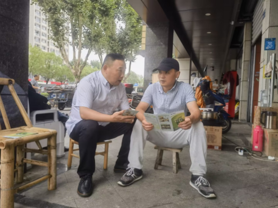 志愿者向零售客户讲解烟草法律法规。