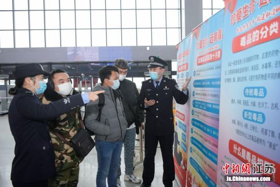 民警向旅客宣传禁毒知识。姜明 摄