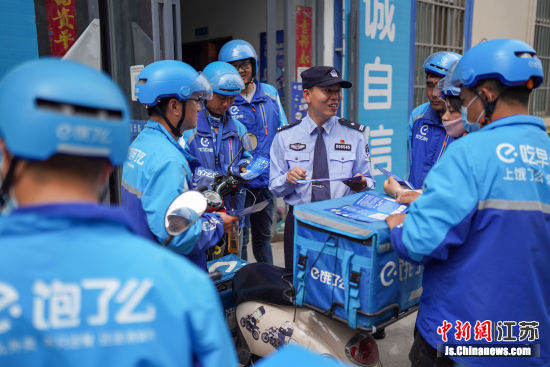 民警向外卖小哥宣传防诈骗知识。