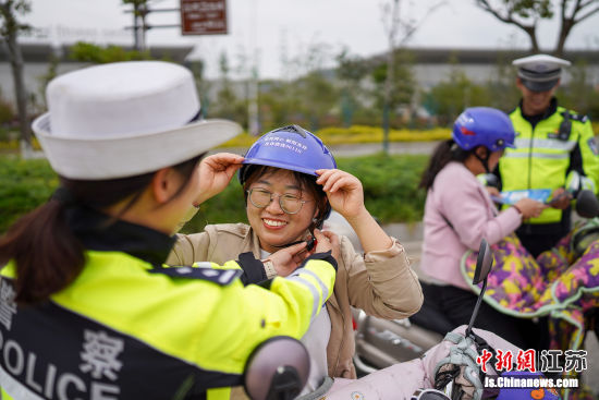 民警免费向群众发送印有防诈骗提醒标语的头盔。