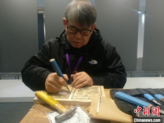 韩国刻手郑灿民演示刻制印版画用的木版. 钟升 摄