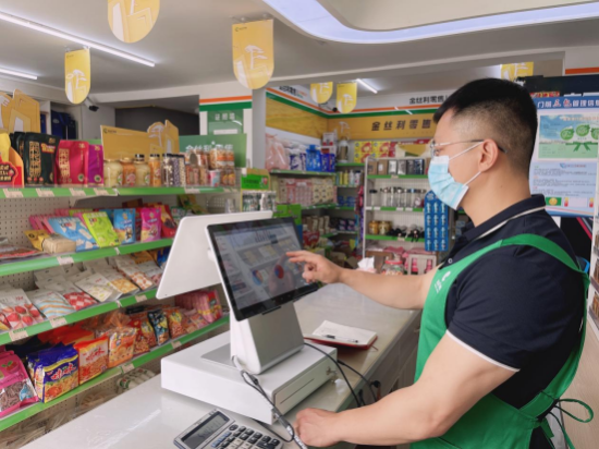 该店铺老板使用终端智慧系统分析经营数据。