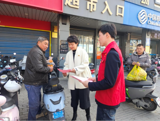 志愿者协助社区发放居民医保宣传单页。江宁烟草供图