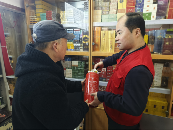 图为红叶志愿者在向零售户普及安全知识。南京烟草三分局供图