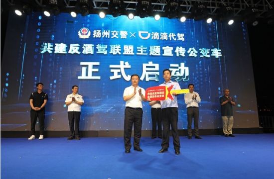 张耀武向反酒驾联盟主题宣传公交车司机递交了“金钥匙”。扬州市公安局交通警察支队供图