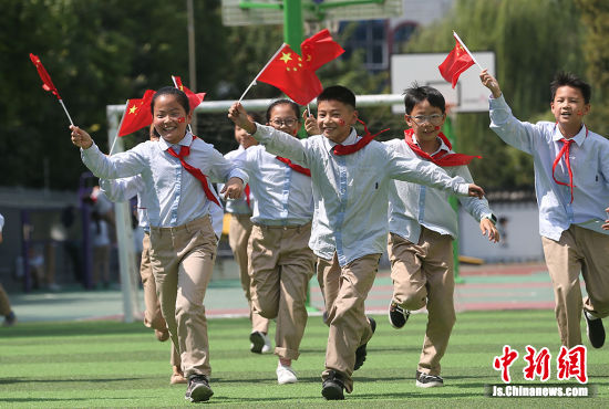 扬州小学生们挥舞国旗迎国庆.董辉 摄