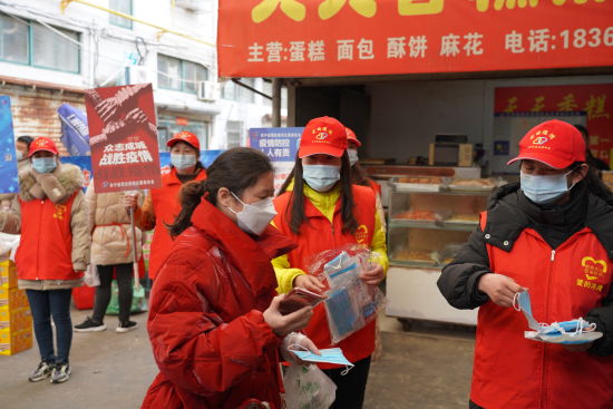 志愿者向市民发放口罩。