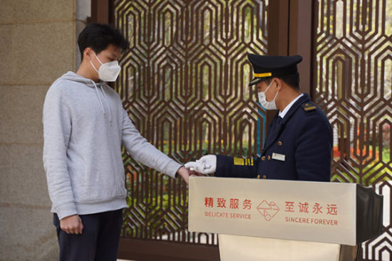 工作人员对进出人员测温。