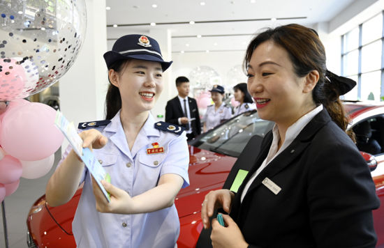 6月15日,青年志愿者走进4S店宣传新出台的车购税税收优惠政策。