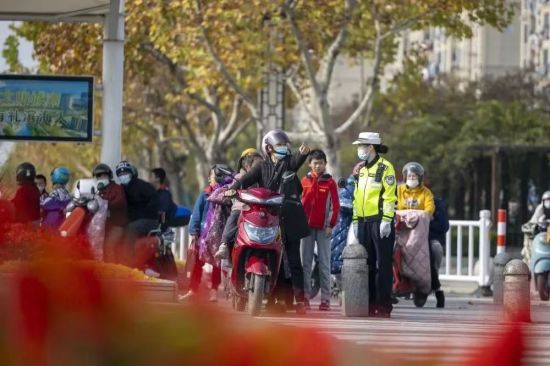 民警在街头宣传“一盔一带”的重要性。