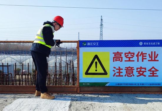 在施工现场,厉洋对临边防护栏、标识标牌等进行检查。