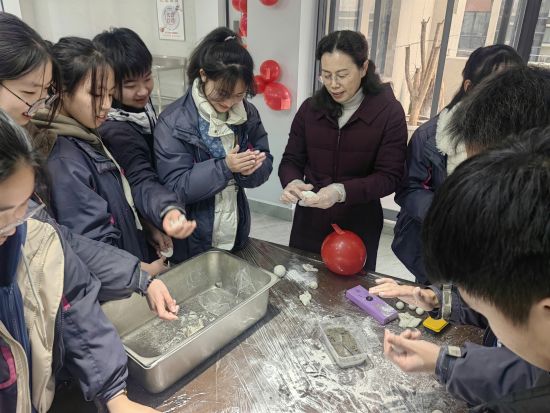 盐城市康居路初中教育集团党委书记陈巧云指导学生包汤圆话团圆。