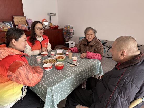 社区志愿者陪于云一家人吃饭。