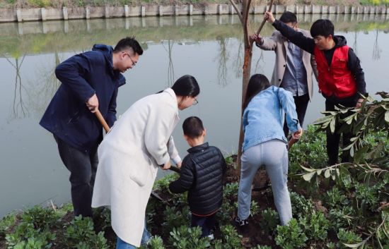 3月11日,位于盐城市亭湖区新兴镇永丰渠岸边呈现一派热闹的植树景象。