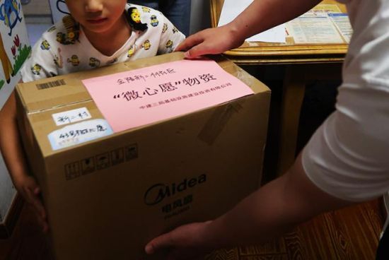 当天,志愿者们入户走访慰问了21户困难儿童家庭,将孩子们的书籍、篮球、玩偶、拼图等“微心愿”礼物送到他们手上。中新社记者 泱波 摄