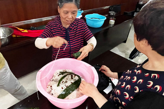 侨眷张阿姨带领大家包粽子。